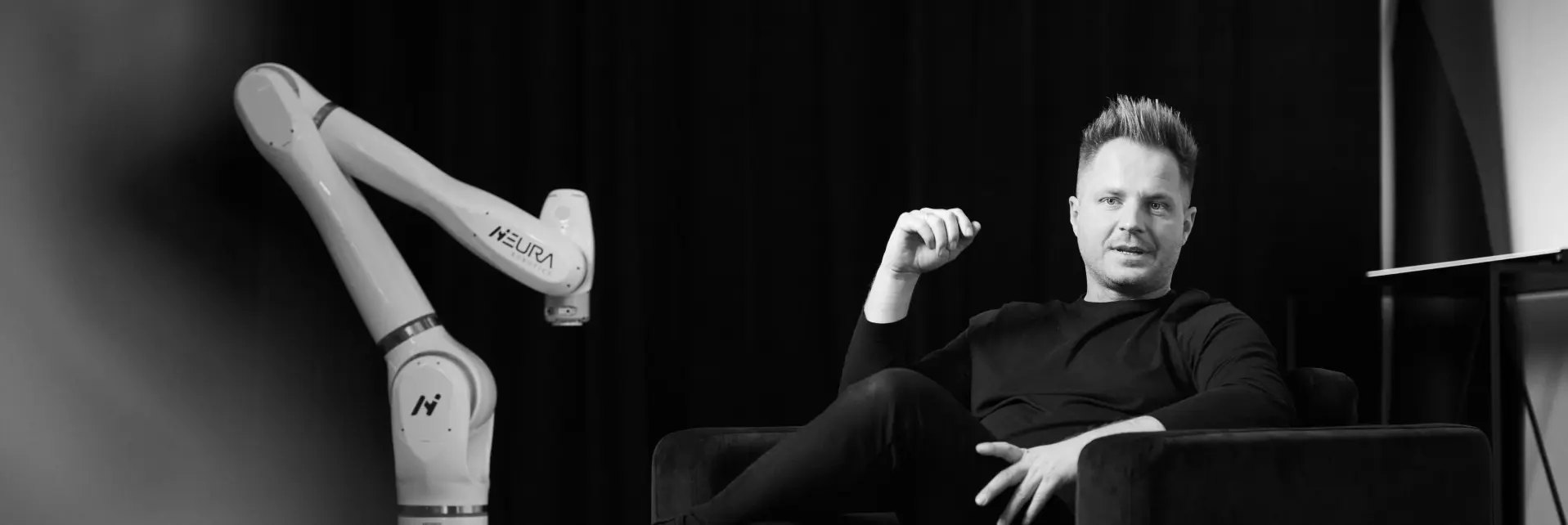 David Reger sitzend vor einer Maschine.